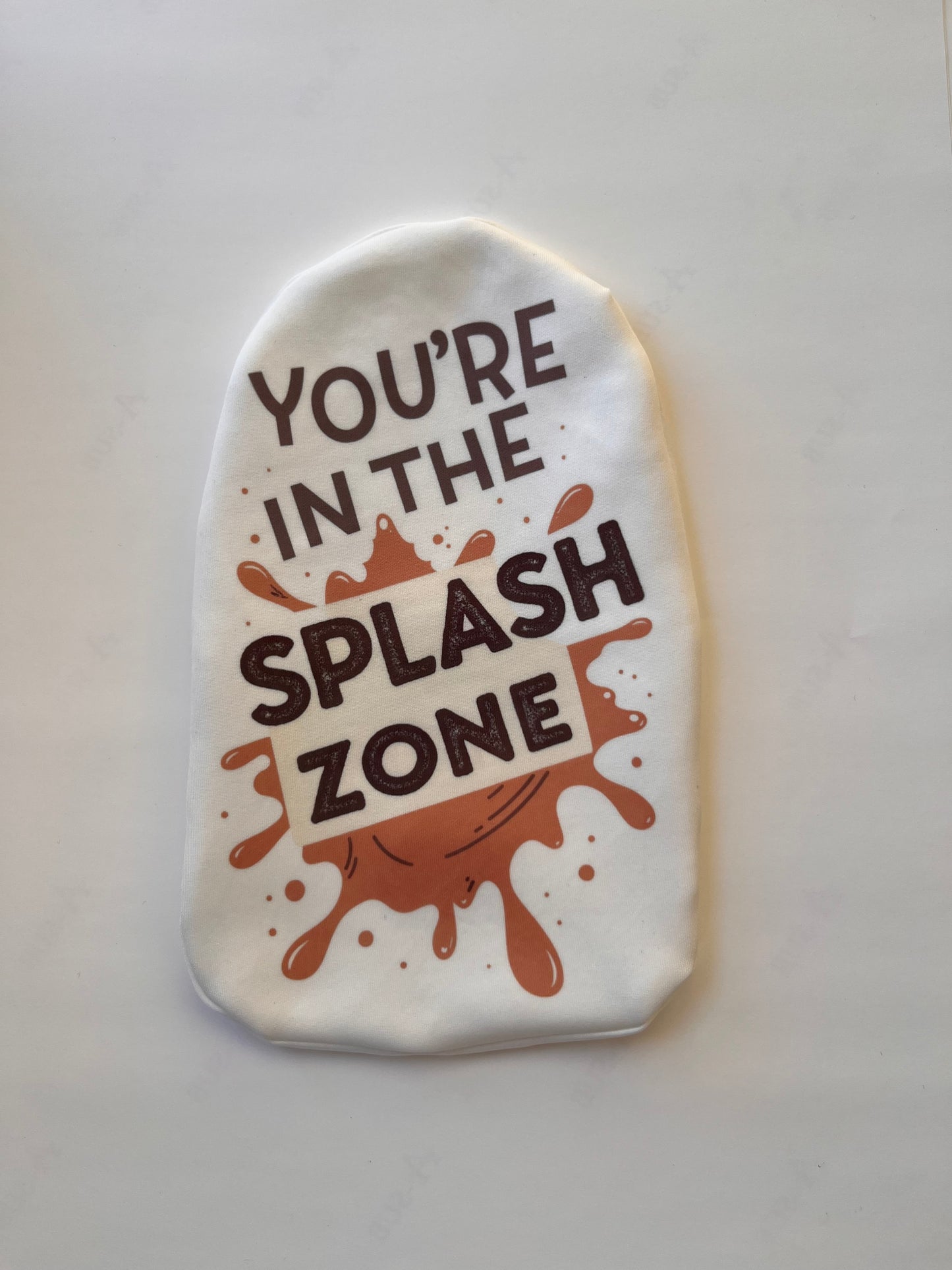 White stoma pouch with "You're in the splash zone" poo-themed joke – cheeky ostomy cover for toilet humor fans.